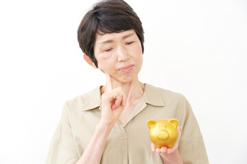 貯金箱を持って考える中年女性　白背景