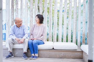 リゾート地で仲良く会話をする高齢の夫婦