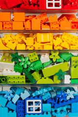 Naklejka premium Lego duplo. LEGO blocks sorting by colors in transparent plastic containers. Storage Ideas in nursery. Space organizing at children's room.