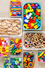 Toy Storage boxs in the children's room. Plastic containers with colorful wooden toys. Organizing and Storage Ideas in nursery. Clean up toys and reduce the clutter. Top view