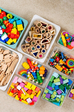 Toy Storage boxs in the children's room. Plastic containers with colorful wooden toys. Organizing and Storage Ideas in nursery. Clean up toys and reduce the clutter. Top view