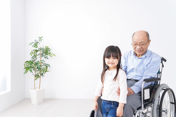 Fototapeta na wymiar 車椅子に乗る高齢男性と女の子