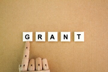 wooden hand with the word grant alphabet letters. the concept of giving and receiving. award concept