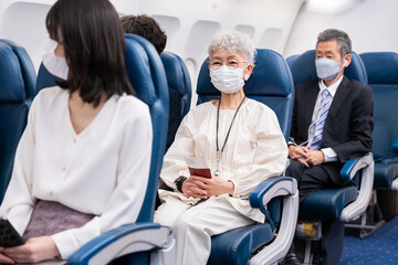 マスクをして飛行機に乗る乗客