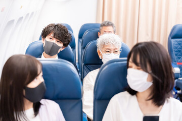 Fototapeta na wymiar マスクをして飛行機に乗る乗客