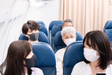 Fototapeta premium マスクをして飛行機に乗る乗客