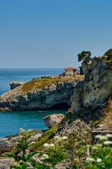 Fototapeta na wymiar Istanbul, Turkey. The rocky shore of the Black Sea with a cave in Sile, beautiful villas on a hill.