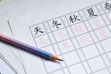 Winter autumn summer in Chinese character practice sheet. Close-up, learning new language with season concept.