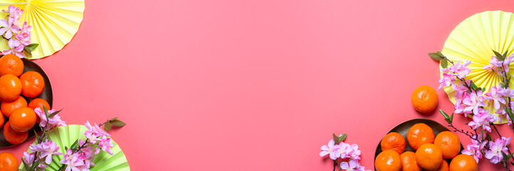 Chinese or lunar new year flat lay with paper decorations, mandarins and flowers on pink