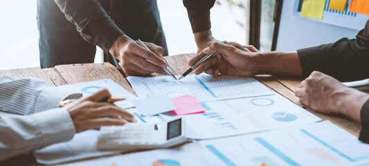 Group of Asian business people meeting, planning, and discussing chart data analytics, financial calculations, and business performance. accounting concepts, marketing.