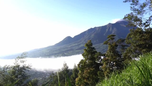 landscape with trees and clouds. hyperlipse or timelipse of clouds and fog on the mountains. beautiful mountain background fast motion clouds with blue sky.
