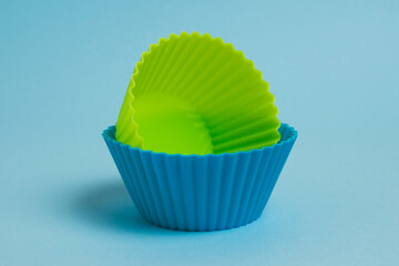 Blue and yellow silicone cupcake molds on a light blue paper background