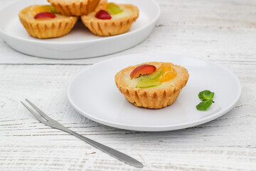 Small fruit pia cake on a textured white background. Kue Pia Buah.