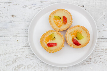 Small fruit pia cake on a textured white background. Kue Pia Buah.
