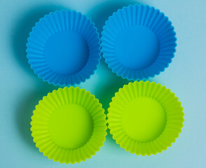 Yellow and blue silicone cupcake molds on a soft blue paper background