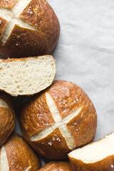 Pretzel buns on a parchment lined baking sheet, German laugenbroetchen on a baking tray