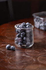 blueberries in a small jar on a dark background