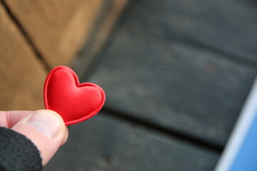 Human hand holding red toy heart. Valentine's Day idea.