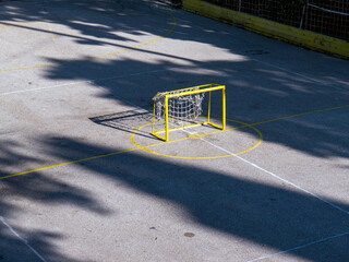 Small kids metal goal on asphalt field top angle front view