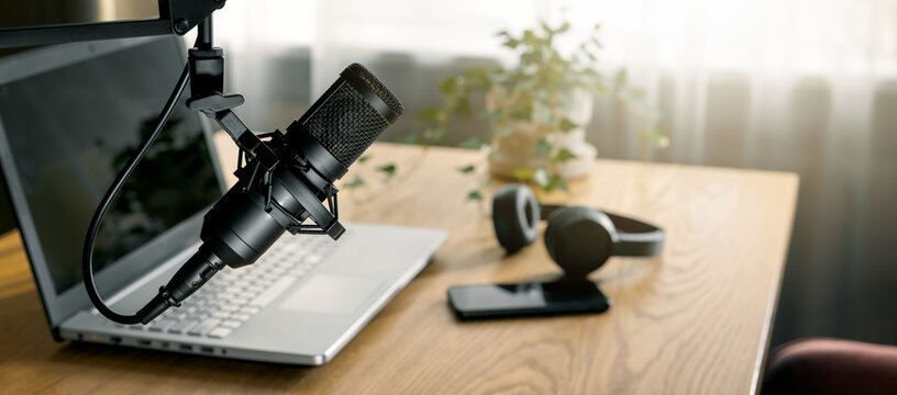 workplace of content creator with microphone, laptop and headphones. home studio for podcasting, online streaming, vlogging. banner with copy space