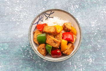Food healthy stir fried chicken add sweet pepper has rice in bowl on blue wood table.