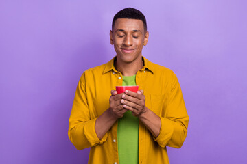 Portrait of cheerful optimistic handsome nice guy wear yellow clothes holding tea mug eyes closed...