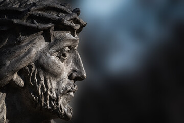 Fragment of antique stone statue Jesus Christ in a crown of thorns as symbol of love, faith and...
