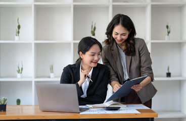 Obraz premium Business idea creative brainstorming sessions for projects Strategic topic of two Asian girls working together data analysis Happy clarification of various financial information at the desk.