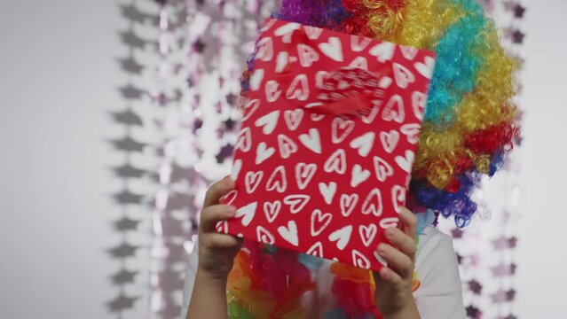 Boy of 10 years old dressed in clown's wig and eyeglasses. 