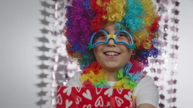 Boy of 10 years old dressed in clown's wig and eyeglasses. 