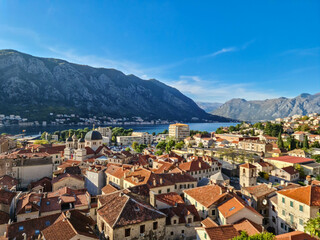 Naklejka na ściany i meble Aerial view of Kotor bay, town and harbour in sunny summer at Adriatic Mediterranean Sea, Montenegro, Balkan, Europe. Fjord winding along coastal towns. Lovcen park. Seen from Kotor fortress wall