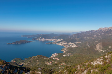 Fototapeta na wymiar Panoramic aerial view on the coastline of Budva and Sveti Nikola Island seen from Goli Vrh, Adriatic Mediterranean Sea, Montenegro, Balkan, Europe. Luxury hotel resorts along Budvanian Riviera.