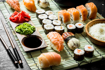 Set of Japanese sushi rolls with sauce and chopsticks.