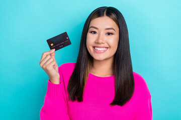 Photo portrait of young promoter vietnamese lady hold new premium black debit ebank card promotion shopping isolated on aquamarine color background