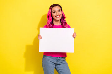 Photo of cute sweet girl dressed vibrant pullover holding white placard empty space isolated yellow color background