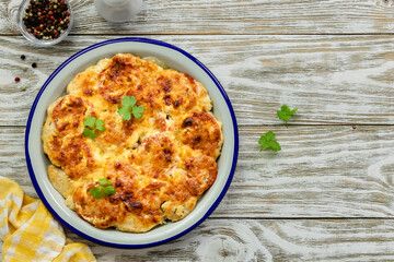 Chicken vegetable bake on wooden background. Top view, copy space, flat lay.