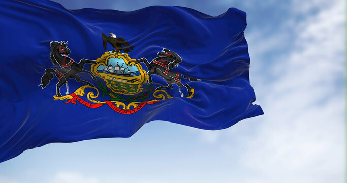 Pennsylvania state flag waving in the wind on a clear day.