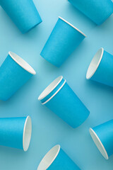 Paper disposable cup on blue background. Vertical photo