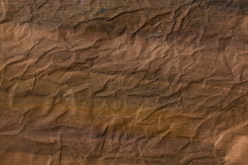 Background in dark, warm colors. Wrinkled surface of paper. Texture, grunge. Earthy colors.