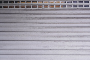 The texture of grey metallic roller shutter door in front of the factory