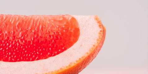 Grapefruit slice against green-pink background.