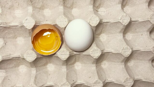 Bright and appetizing raw yolk in an eggshell. Eggs in a chicken egg container.