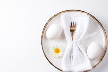 Serving the Easter table. A plate with a white napkin fork and an Easter egg on a white background