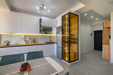 A sleek white studio apartment with a fully functional kitchen