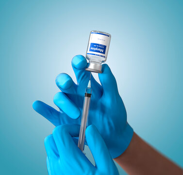 Morphine. Doctor holding with hands with latex gloves the bottle of morphine and syringe