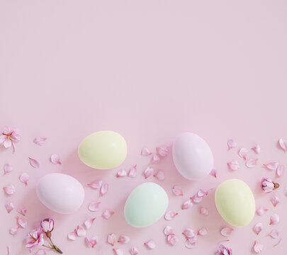 Easter background: Easter eggs on a pink background with blooming cherry blossoms and petals © Andreas Prott