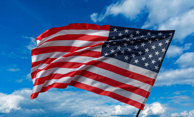 American flag on the blue sky. The American flag waving in the blue sky.