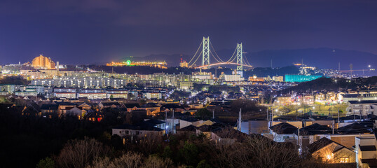 Fototapeta na wymiar Panoramic View of in Residential Suburb and Suspension Bridge at Night