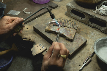 Jeweler at work in jewelry. Desktop for craft jewelry making with professional tools. Close up view...