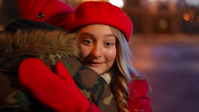 Hypocritical teen girlfriend thanking for Valentine's gift hugging boyfriend rolling eyes sighing. Portrait of insincere Caucasian teen girl dating with boy in urban city at night